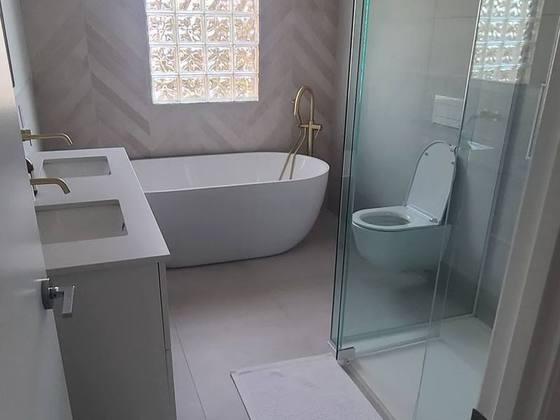 Salle de bain avec douche vitrée et bain autoportant