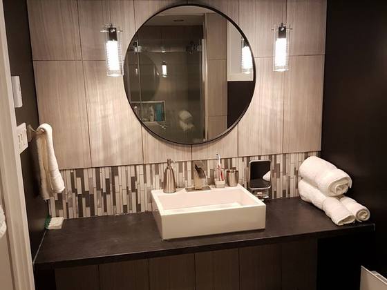 Vanité de salle de bain avec miroir rond et dosseret de mosaïque