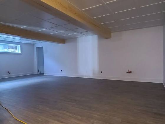 Grande salle de sous-sol terminée avec plancher